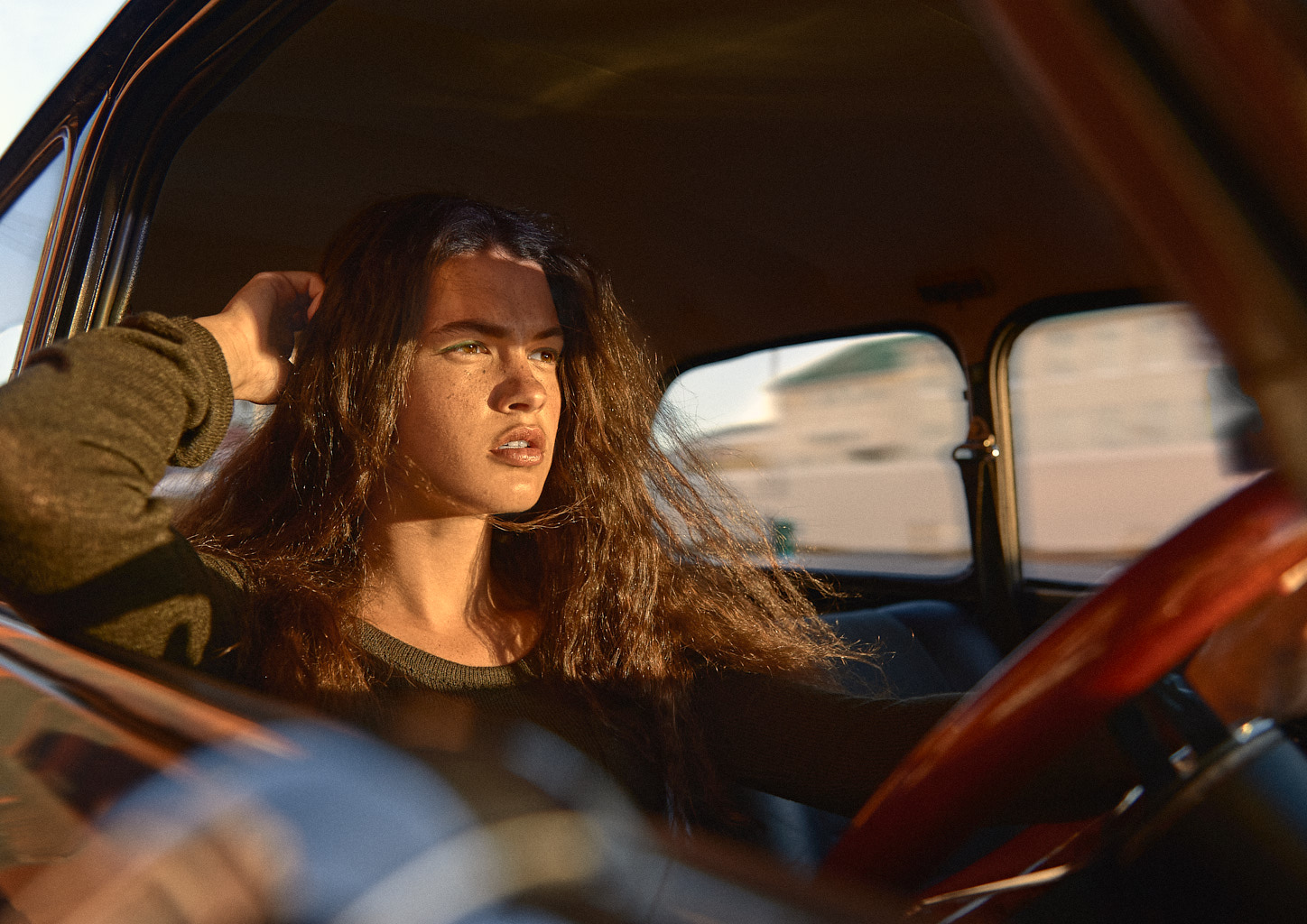 Woman driving a car of the brand Mini.